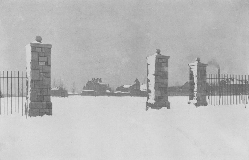 Black and white photo of the campus main entrance covered in snow