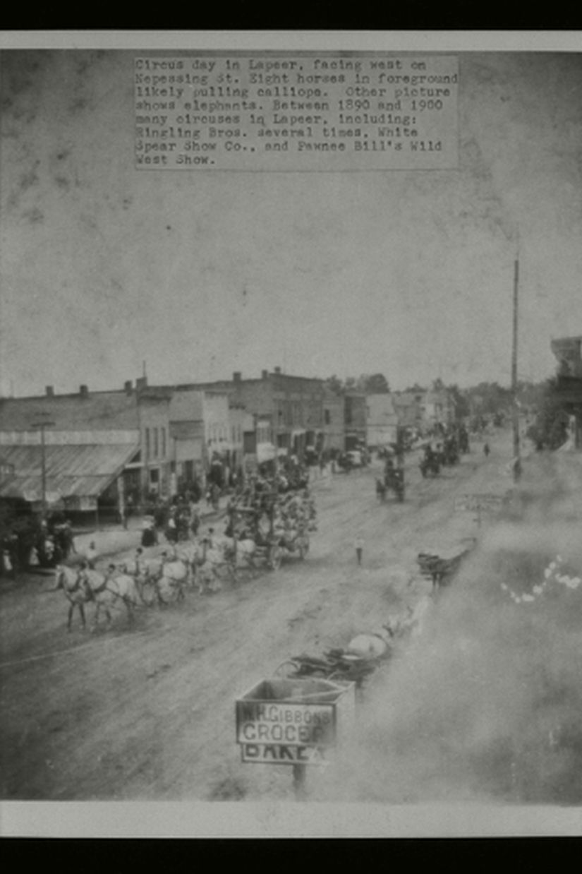 Picture of a street scene from above with horses pulling a calliope during a circus parade.