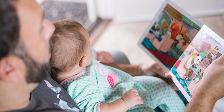 Dad reading to his baby